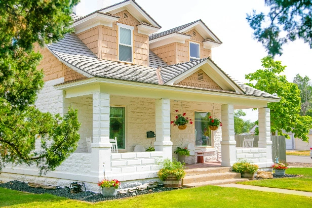 a white and peach-colored two story house sits on a sunny lawn